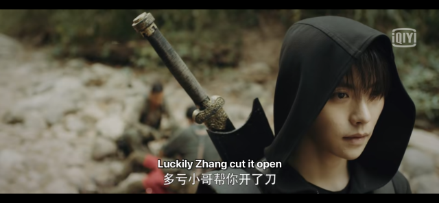 We can see Wu Xie and Pangzi fuzzily in the background, with Pangzi saying, "Luckily Zhang [Xiaoge] cut it out." ZQL is in the foreground facing away with wide eyes and a shell shocked expression