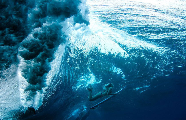 Into the blue (surfer diving below the waves)