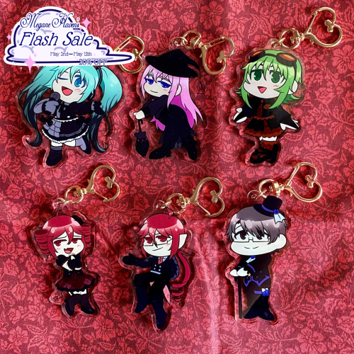 Acrylic charms of Vocaloid and UTAU characters in gothic clothing. Featured are Miku, Luka, Gumi, Teto, Ted, and Kiyoteru.