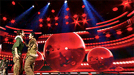 A gif from their performance of She A Wolf at Show Champion. They are wearing outfits with military colors and furs, Ten with khaki brown and Hendery with military green.