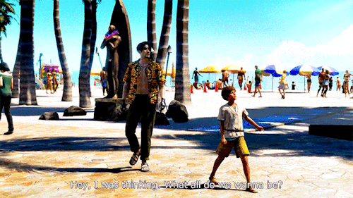 Majima and a child stand by the beach in Hawaii. Majima is dressed in a floral shirt and dark pants with sandals. The kid points off screen asking "Hey, I was thinking. What all do we wanna be? Majima asks "Wanna be?" in response.