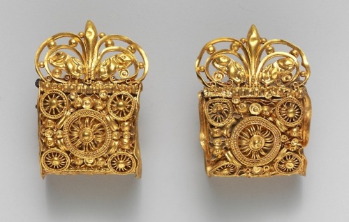 Pair of gold baule-type earrings with symmetrical palmettes flanked by repoussé crouching haresEtrus