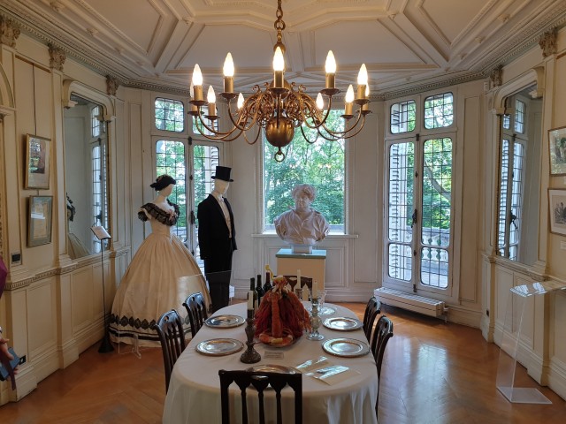 a photo of the bright, white dining room with large windows leading onto a terrace