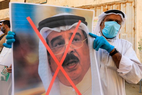 A Palestinian man carries a portrait of the Bahraini King during a protest in Deir al-Balah, on Sept