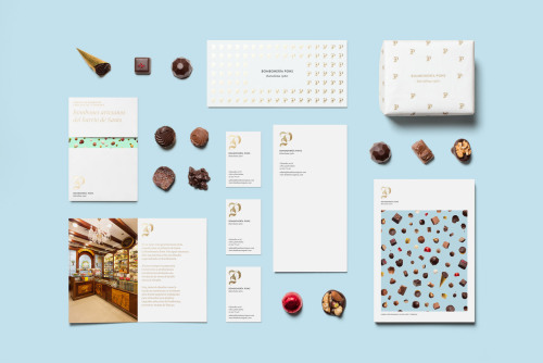 Rebranding for a chocolatier in Spain. The complementary photography of the bombones against baby bl