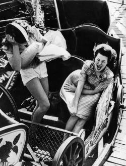 Undr: Kurt Hutton. Two Young Women Having Trouble With Their Skirts On A Fairground