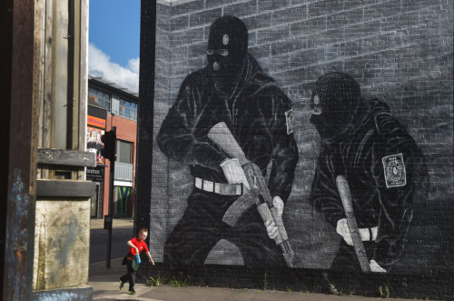 A young boy runs past a loyalist paramilitary mural on Oct. 13 in Belfast, Northern Ireland.