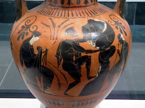 Sisyphus, watched by Persephone and Hades, undergoes his punishment in the Underworld.  Attic black-