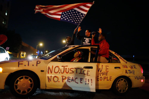 politics-war: Protesters wave an upside-down American flag after blocking an intersection.