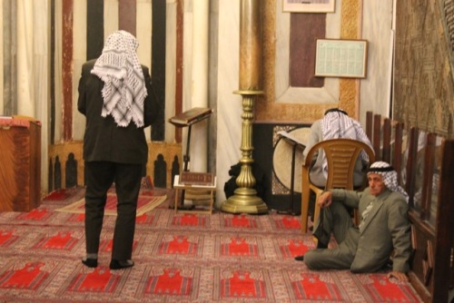 landofolives:Ornate chandelierElderly Palestinian men, wearing keffiyehs, praying. There are few oth