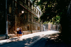 thelastenchantments:Two students walking along Brasenose Lane.  I like the tree, the dappled sunlight in the street, the sense of love and togetherness that suffuses the whole picture.  Oxford’s a great place to be in love - really the point of The