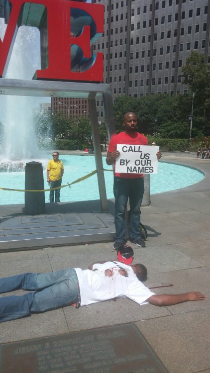 thatblackveganguy:  ras-al-ghul-is-dead:  A silent protest in Love Park, downtown Philadelphia orchestrated by performance artists protesting the murder of Michael Brown in Ferguson. The onslaught of passerby’s  wanting to take photos with the statue