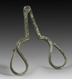 archaicwonder:   Roman Bronze Castration Tongs, 1st-4th Century AD Two arms hinged and closed by a screw nut form an  oval-like ring, accompanied by the serrated teeth of two longer arms. The  penis was kept out of harm’s way by insertion through the