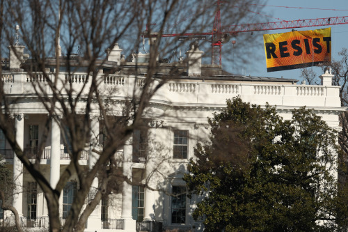 mysticben:politico:Protesters have unfurled a giant orange and yellow banner that says “RESIST” from