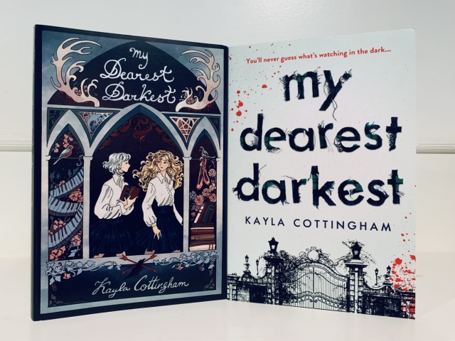 Shown are the Fox & Wit special edition (with cover art depicting two young women classmates, pictured with piano keys, textbooks, and ballet shoes) and the regular edition (with cover art depicting the wrought-iron gates of a school and blood spatter) of MY DEAREST DARKEST. Photo by AHS.