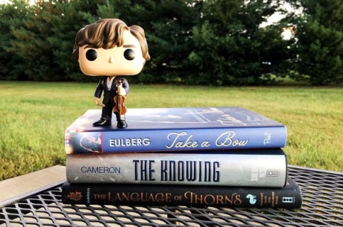 Sherlock with some of my unread books, including The Knowing, which I have started and is celebratin