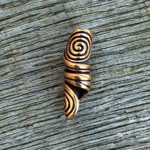 This bronze hair bead is decorated with twin spiral motifs which are inspired by prehistoric Irish a