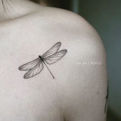 Wrist tattoo of a tiny minimalistic dragonfly