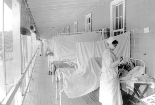 A nurse takes the pulse of a patient in the influenza ward of the Walter Reed hospital in Washington