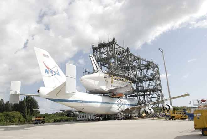 “Space shuttle Discovery is lowered onto the Shuttle Carrier Aircraft in the mate-demate