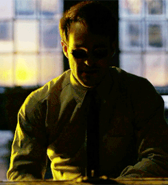 Matt Murdock kneeling in front of a chest, bowing his head, and doing the Sign of the Cross