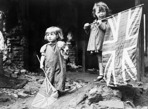 worldwar-two:Two small girls waving their flags in the rubble of Battersea, snapped by an anonymous 