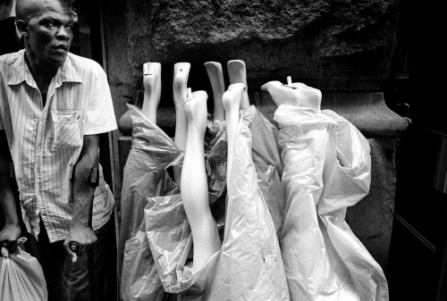 a man on crutches standing next to a bunch of mannequins legs