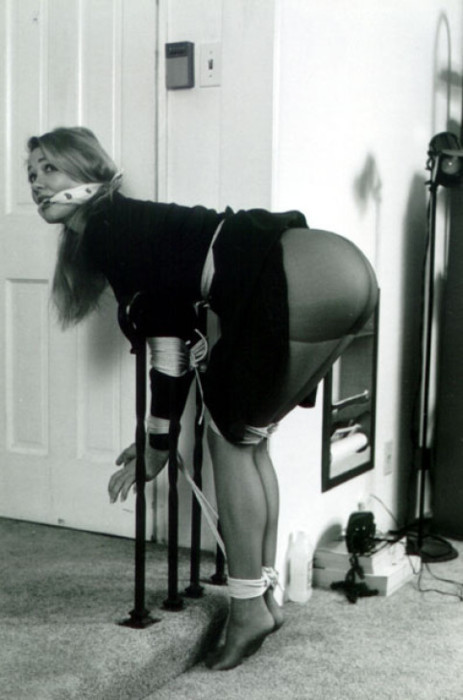 eenslaved:  “Mmmmphhh,” she wails as at the long, flat paddle cracks down soundly across her ass. She throws her head back and then lets it drop back down again. Her fingers twitch restlessly, and she sobs loudly through the crude gag. Everything