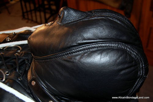 mistressaliceinbondageland: I lash him to the bondage table using thick white rope. His dick gets harder and harder, bulging against the leather catsuit while I restrain the rest him tighter and tigher. I add a sensory deprivation hood and a powerful