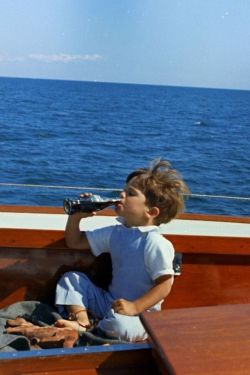 mrs-kennedy-and-me:  John F. Kennedy Jr. enjoying some Coca-Cola, aboard his fathers yacht, c. 1963 