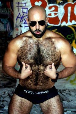 A hairy guy tweaking his nipples.