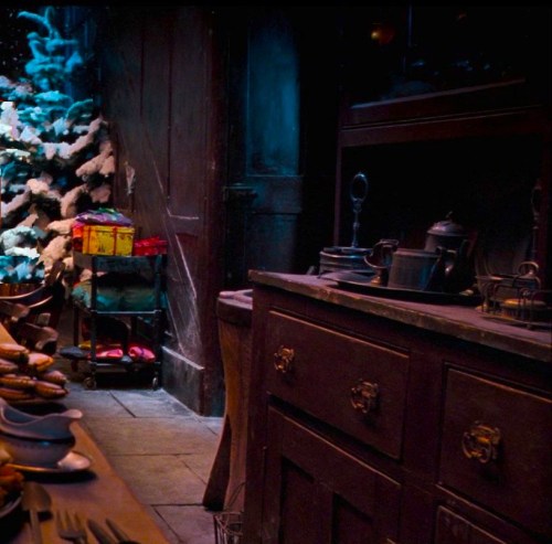 The kitchen of 12 Grimmauld Place decorated for Christmas with a snow-covered tree, London 