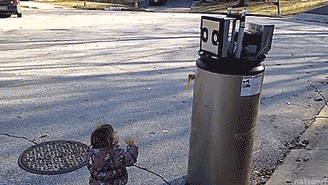 tastefullyoffensive:  Little girl is excited to meet a robot (broken water heater).