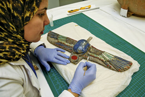 At the Grand Egyptian Museum Ceramics Restoration Laboratory in Cairo, the restorer carries out a cl