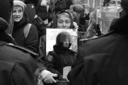 curb-slap:  A pro-European demonstrator holds a mirror which reflects a group of riot police officers standing guard in Kiev, Ukraine. 