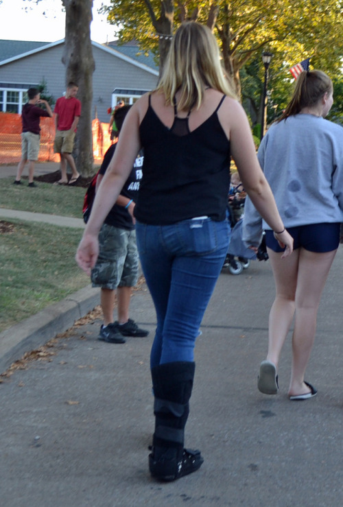 Three fair goers, one with a walking air cast, two with cam walkers.