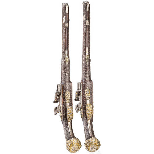 A pair of chiseled, gold and silver inlaid flintlock pistols crafted in France, circa 1810-1820.from