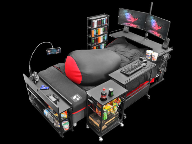 gamer pad bed equipped with monitors, desks, chips, and way too much monster