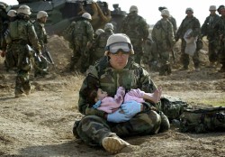 Navy Corpsman Richard Barnett of Camarilo, Calif. checks the heart of a young Iraqi boy as other Navy medics treat the boy&rsquo;s older sister, right, after the two children and their family were caught in a crossfire between US Marines and Iraqi soldier