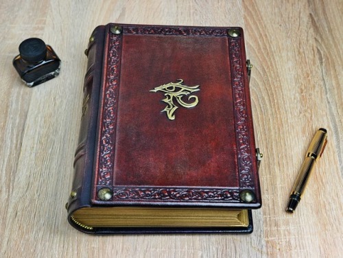 Reddish leather journal with the gilded Horus eye…