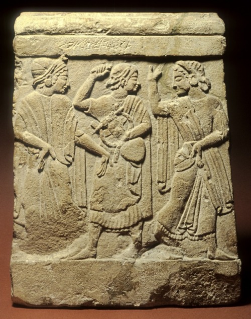Limestone relief from an Etruscan funerary cippus, showing a man with a lyre between two dancers.  A