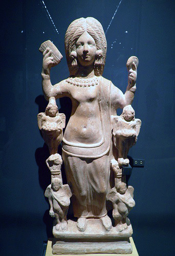 The Goddess Aphrodite, or a young woman dressed as her, holding a comb and a mirror supported by fou