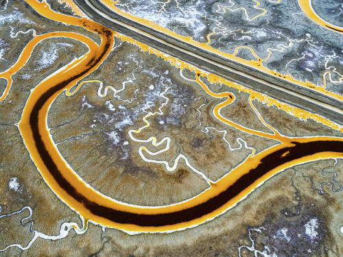 San Fransisco Bay salt mines. There are colorful microorganism in those salt ponds. The color change