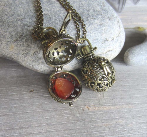 Carnelian stone inside a witchy little locket.  www.WhiteMoonWitchcraft.etsy.com