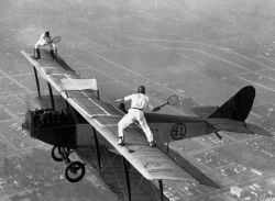 Professional Airwalkers Gladys Roy And Ivan Unger Playing Tennis On The Wing Of A