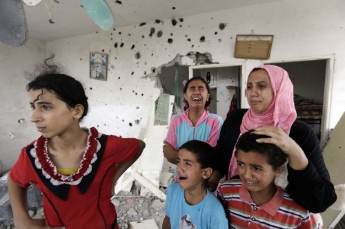 Palestinian Salwa Shabat, accompanied by some of her children, weep as they inspect the damage upon 