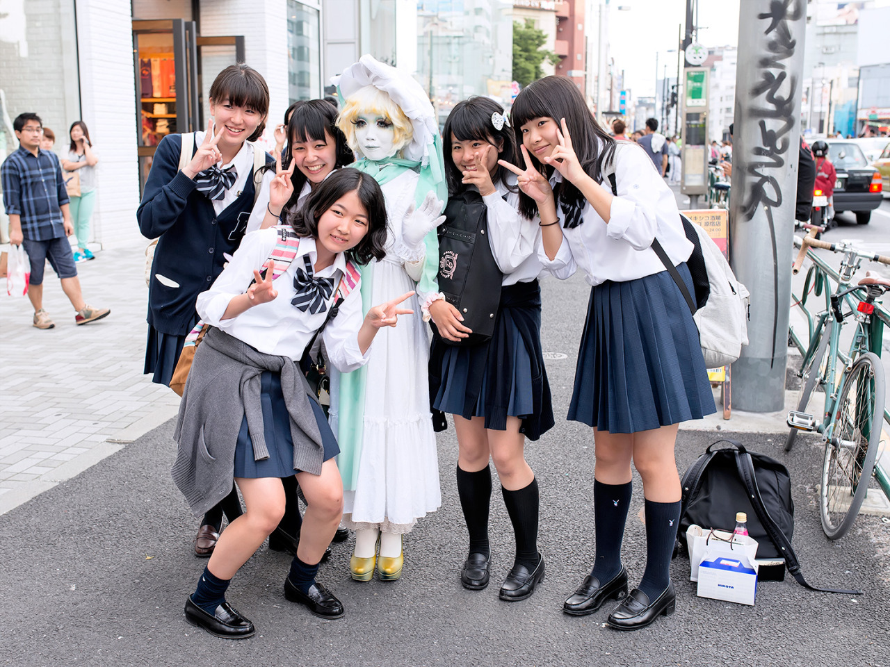 Japanese shironuri artist Minori posing with a group of schoolgirls on the street in Harajuku. Whenever Minori is wandering around Harajuku, so many people stop to take pictures with her.