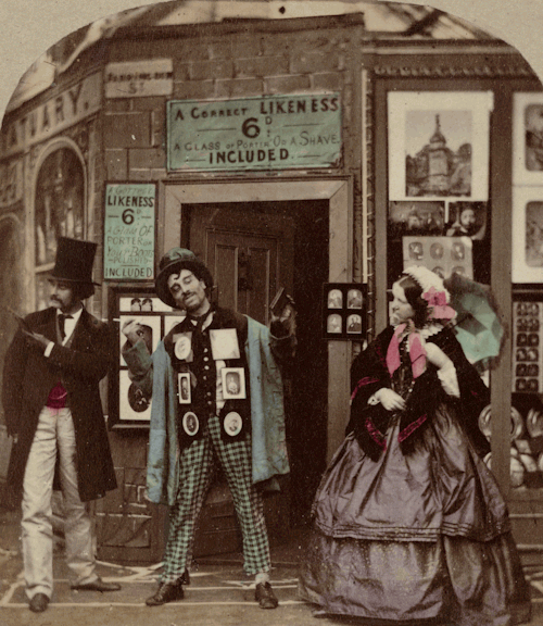 chubachus:Staged scene of a man advertising photographs to two passersby in front of a portrait stud