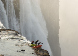 conflictingheart:  desre tate photographs kayakers steve fisher, dale jardine, and sam drevo standing at the edge of victoria falls’ 350 foot drop before absailing down. during the autumn dry season, the river’s flow is at a safe enough level that