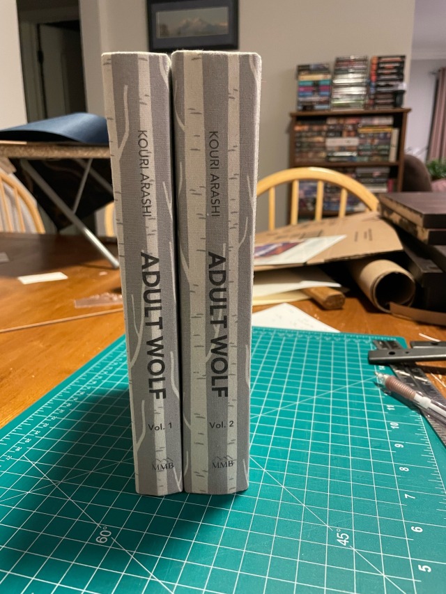 two volumes of Adult Wolf, shown side by side, straight on the spine